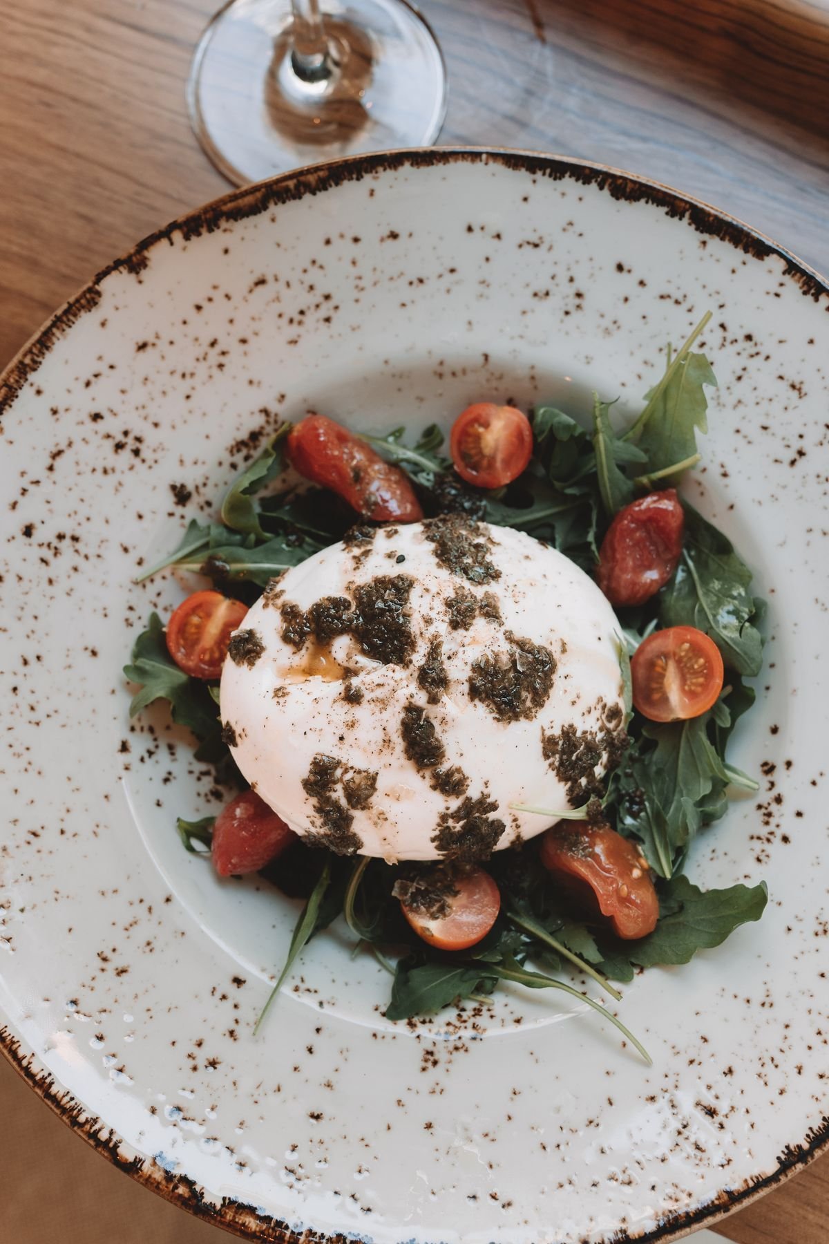 Burrata, cherry tomatoes and arugula on a plate