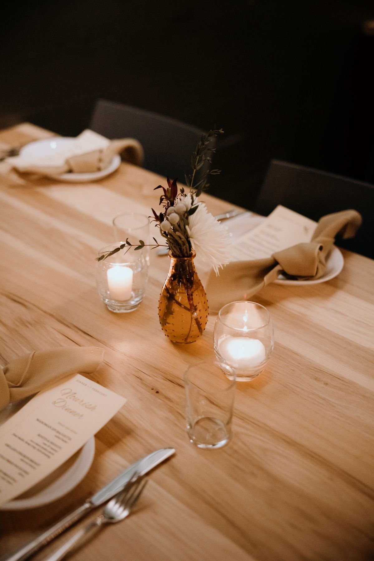 Candlelit restaurant table with glassware and flowers