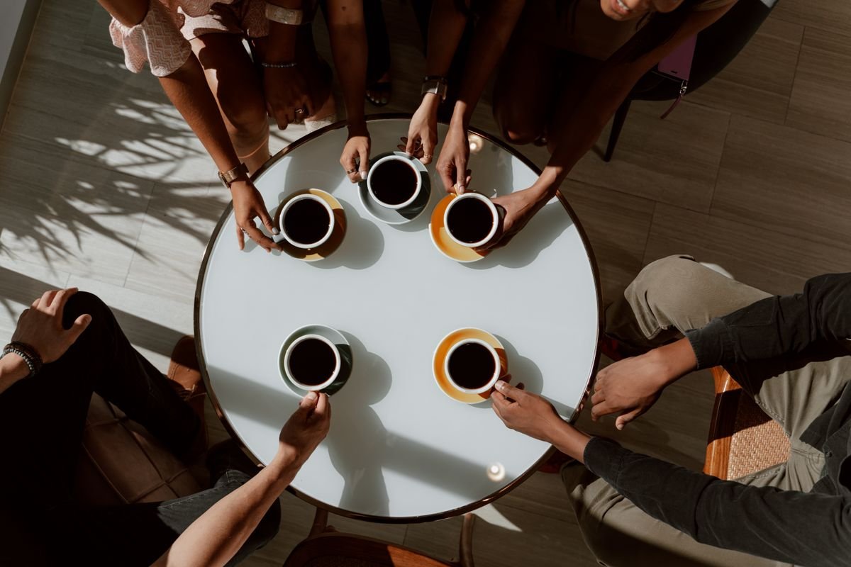 Friends sharing coffee around a cafe table